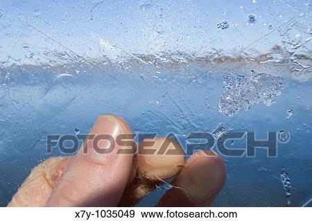 A hand holds a sheet of ice View Large Photo Image Stock Photo - A hand holds a sheet of ice. Fotosearch