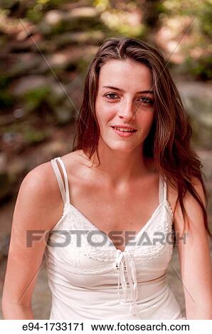 A happy 20 year old brunette woman wearing a white top looking directly at the camera. View Large Photo Image Stock Image - A happy 20 year old brunette woman wearing a white top looking directly at the camera.. Fotosearch