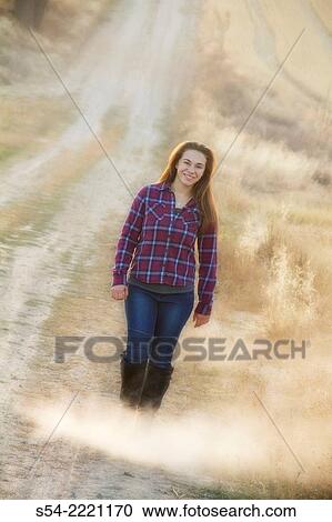 A happy teen girl walking on a rural dirt road. View Large Photo Image Stock Image - A happy teen girl walking on a rural dirt road.. Fotosearch