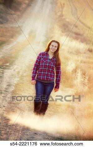 A happy teen girl walking on a rural dirt road. View Large Photo Image Stock Photograph - A happy teen girl walking on a rural dirt road.. Fotosearch
