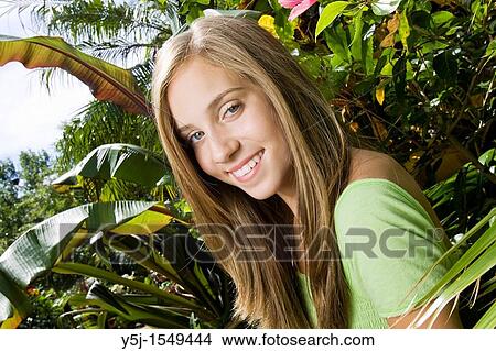 Picture - A happy teenage girl in garden on a sunny afternoon. Fotosearch
