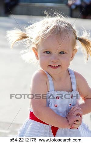 Stock Photograph - A happy toddler girl, almost two years old, outdoors in the summer.. Fotosearch