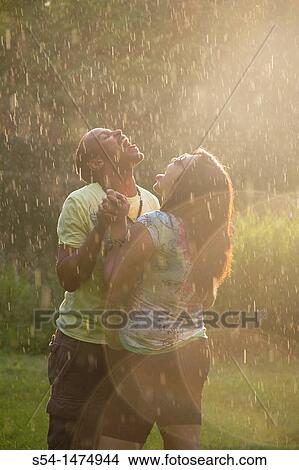 A happy, young, african-american couple playing in the rain View Large Photo Image Picture - A happy, young, african-american couple playing in the rain. Fotosearch