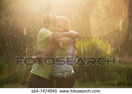 A happy, young, african-american couple playing in the rain View Large Photo Image Stock Photography - A happy, young, african-american couple playing in the rain. Fotosearch