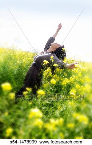 Stock Photo - A happy young caucasian woman in a field of canola. Fotosearch