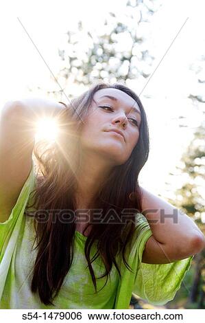 Stock Photograph - A happy young caucasian woman outdoors. Fotosearch