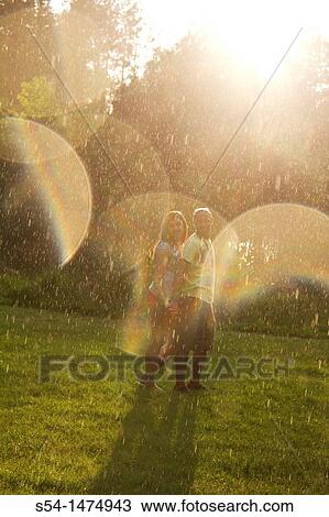 A happy, young couple playing in the rain View Large Photo Image Stock Image - A happy, young couple playing in the rain. Fotosearch