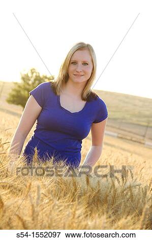 Stock Photo - A happy young woman at a farm in Lewiston, Idaho, USA. Fotosearch