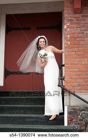 A happy young woman in a bridal gown, standing by a church in Rosalia, Washington, USA. View Large Photo Image Picture - A happy young woman in a bridal gown, standing by a church in Rosalia, Washington, USA.. Fotosearch