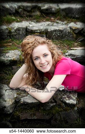A happy young woman outdoors, lying on stone steps View Large Photo Image Stock Image - A happy young woman outdoors, lying on stone steps. Fotosearch
