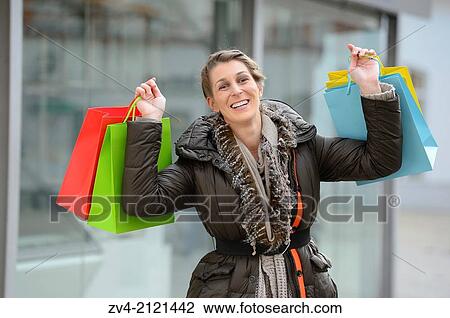 A happy young woman with her bags from a shopping tour in a city in Germany. View Large Photo Image Stock Image - A happy young woman with her bags from a shopping tour in a city in Germany.. Fotosearch