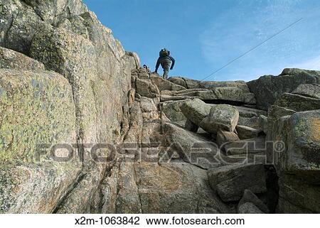 A Hiker climbs the rock ledge near the summit of Mount Chocorua Located in the White Mountains of New Hampshire USA View Large Photo Image Stock Image - A Hiker climbs the rock ledge near the summit of Mount Chocorua Located in the White Mountains of New Hampshire USA. Fotosearch