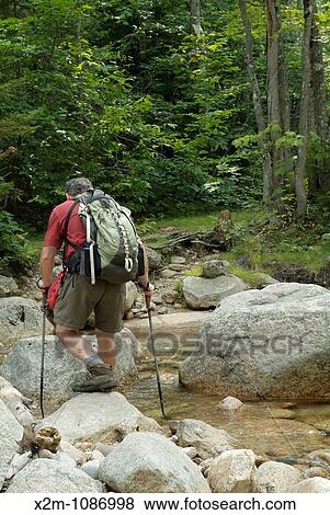 A hiker crosses a section of the Swift River on Sawyer River Trail during the summer months Located in the White Mountains, New Hampshire USA View Large Photo Image Stock Photo - A hiker crosses a section of the Swift River on Sawyer River Trail during the summer months Located in the White Mountains, New Hampshire USA. Fotosearch