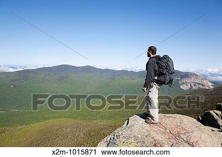 Stock Image - A hiker enjoys the views from the summit of Mount Liberty during the summer months Located in the White Mountains, New Hampshire USA. Fotosearch