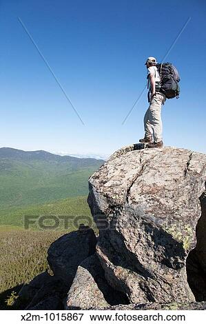 Stock Photo - A hiker enjoys the views from the summit of Mount Liberty during the summer months Located in the White Mountains, New Hampshire USA. Fotosearch