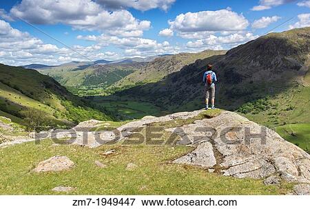 A hiker looks out over Seathwaite valley from Sour Milk Gill on a sunny day in the Lake District, UK. View Large Photo Image Stock Photo - A hiker looks out over Seathwaite valley from Sour Milk Gill on a sunny day in the Lake District, UK.. Fotosearch