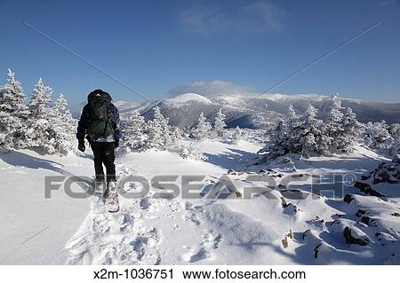 Stock Image - A hiker on the summit of Mount Pierce in the White Mountains, New Hampshire USA The Presidential Range can be seen in the background. Fotosearch