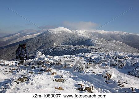 A hiker on the summit of Mount Pierce in the White Mountains, New Hampshire USA The Presidential Range can be seen in the background View Large Photo Image Stock Photo - A hiker on the summit of Mount Pierce in the White Mountains, New Hampshire USA The Presidential Range can be seen in the background. Fotosearch