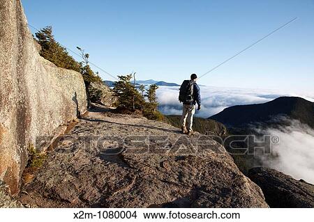 A hiker takes in the view of undercast from the summit of Mount Osceola in the White Mountains, New Hampshire USA View Large Photo Image Picture - A hiker takes in the view of undercast from the summit of Mount Osceola in the White Mountains, New Hampshire USA. Fotosearch
