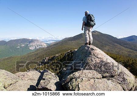 A hiker takes in the views of Franconia Notch from the summit of Mount Liberty during the summer months Located in the White Mountains, New Hampshire USA View Large Photo Image Stock Photograph - A hiker takes in the views of Franconia Notch from the summit of Mount Liberty during the summer months Located in the White Mountains, New Hampshire USA. Fotosearch