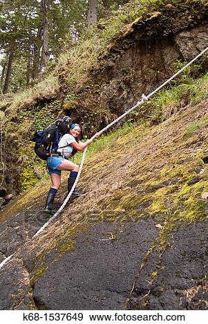 a hiker uses a rope to climb up a steep slope on Nootka Island, BC, Canada View Large Photo Image Stock Photo - a hiker uses a rope to climb up a steep slope on Nootka Island, BC, Canada. Fotosearch