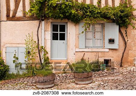 Stock Photo - A house facade decorated with plants in the village of Noyers sur Serein.. Fotosearch