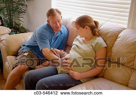 A husband affectionately pats the belly of his nine-month-pregnant wife at home in Lake Forest, CA. View Large Photo Image Stock Image - A husband affectionately pats the belly of his nine-month-pregnant wife at home in Lake Forest, CA.. Fotosearch