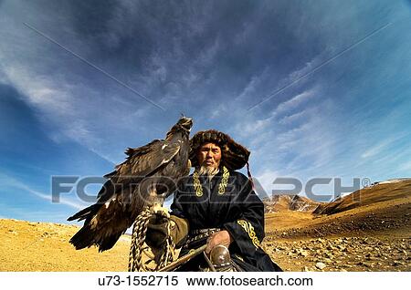 Stock Photography - A Kazakh eagle hunter with his Golden eagle in western Mongolia.. Fotosearch