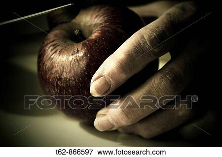 Stock Photo - A knife cutting a red apple Still Life. Fotosearch