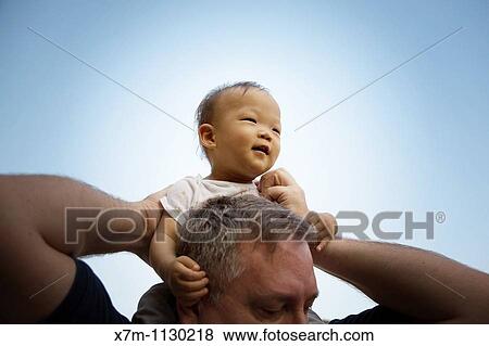 A Korean baby boy is given a ride on the shoulders of a large Caucasian man View Large Photo Image Stock Photo - A Korean baby boy is given a ride on the shoulders of a large Caucasian man. Fotosearch
