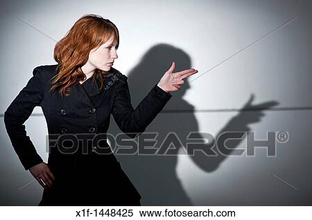 A late teen early 20s single woman girl with red hair pointing her fingers like a gun, casting shadow, UK View Large Photo Image Stock Photography - A late teen early 20s single woman girl with red hair pointing her fingers like a gun, casting shadow, UK. Fotosearch