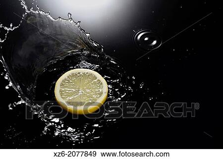 A lemon slice splashing in water on black background. View Large Photo Image Stock Photo - A lemon slice splashing in water on black background.. Fotosearch