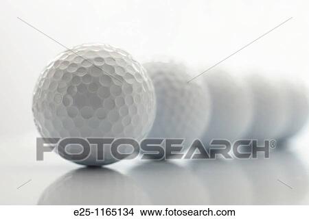 Picture - A line of 5 reflected golf balls on a white background. Fotosearch
