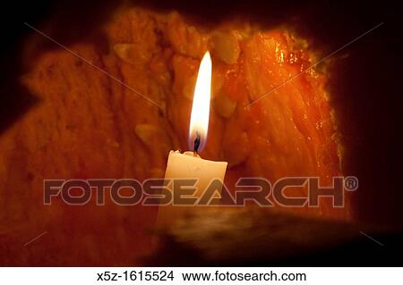 A lit candle inside a Jack O? lantern View Large Photo Image Picture - A lit candle inside a Jack O? lantern. Fotosearch