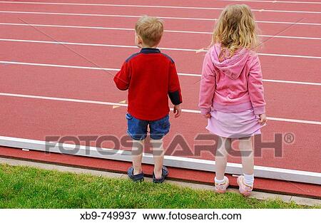 A little boy and girl stand beside a track View Large Photo Image Stock Photo - A little boy and girl stand beside a track. Fotosearch