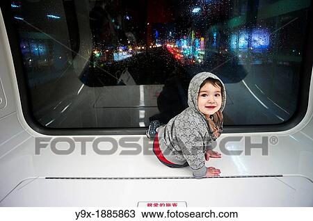 A little boy sits at the front of a train peering out the window View Large Photo Image Stock Image - A little boy sits at the front of a train peering out the window. Fotosearch