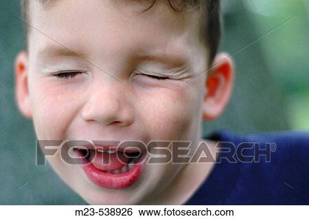 A little boys closes his eyes and makes a funny face View Large Photo Image Stock Photograph - A little boys closes his eyes and makes a funny face. Fotosearch