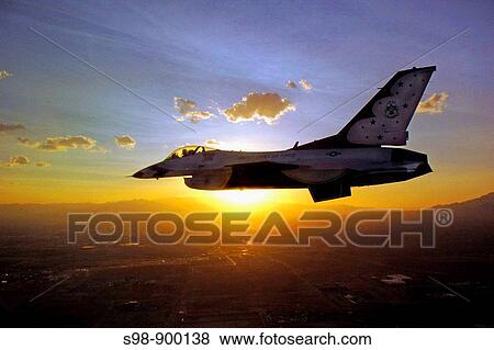 A lone F-16 Fighting Falcon from the U S Air Force Thunderbirds flies against the sunrise. The demonstration squadron has recently released its 2009 schedule View Large Photo Image Stock Photo - A lone F-16 Fighting Falcon from the U S Air Force Thunderbirds flies against the sunrise. The demonstration squadron has recently released its 2009 schedule. Fotosearch