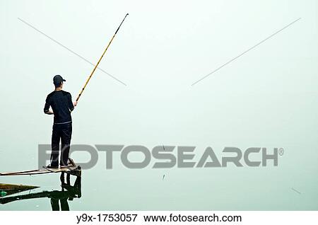 Stock Photo - A lone fisherman at at West Lake in Hanoi, Vietnam. Fotosearch