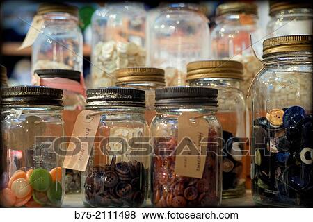 A lot of buttons in glass jars with a description and a price in a warehouse, London, England, UK. Europe. View Large Photo Image Stock Photo - A lot of buttons in glass jars with a description and a price in a warehouse, London, England, UK. Europe.. Fotosearch