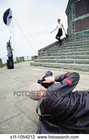 A male fashion photographer taking photographs of a slim female model, outdoor location, UK View Large Photo Image Stock Image - A male fashion photographer taking photographs of a slim female model, outdoor location, UK. Fotosearch