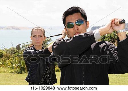 Stock Photo - a man and a woman golfing. Fotosearch