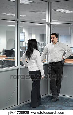 A man and woman talking in the corner of an office View Large Photo Image Stock Photography - A man and woman talking in the corner of an office. Fotosearch