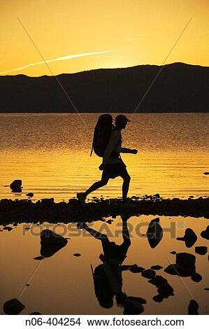 A man backpacking along the shore of Lake Tahoe before dawn. View Large Photo Image Picture - A man backpacking along the shore of Lake Tahoe before dawn.. Fotosearch