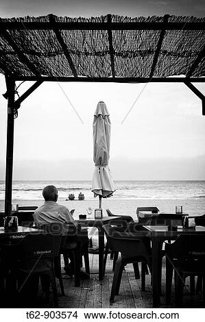 A man enjoying a well deserved break by the sea Beach vacations View Large Photo Image Picture - A man enjoying a well deserved break by the sea Beach vacations. Fotosearch