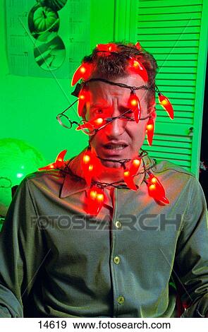 a man experiences frustration while being wrapped in christmas red pepper light string and getting his glasses knocked off, Seattle, Washington USA View Large Photo Image Stock Photo - a man experiences frustration while being wrapped in christmas red pepper light string and getting his glasses knocked off, Seattle, Washington USA. Fotosearch