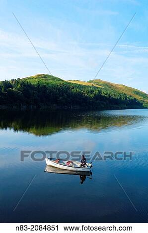 A man fishing from a boat at Llyn (Lake) Clywedog, Llanidloes, Powys, Wales, UK. View Large Photo Image Stock Image - A man fishing from a boat at Llyn (Lake) Clywedog, Llanidloes, Powys, Wales, UK.. Fotosearch