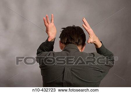 A man from the mid-back up as seen from the rear, with his hands held up in the air View Large Photo Image Stock Image - A man from the mid-back up as seen from the rear, with his hands held up in the air. Fotosearch