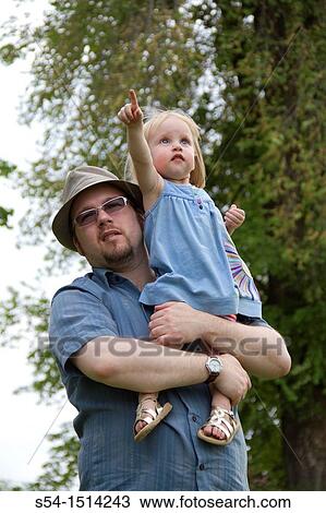 A man holding his young daughter at a park in Spokane, Washington, USA. View Large Photo Image Stock Image - A man holding his young daughter at a park in Spokane, Washington, USA.. Fotosearch