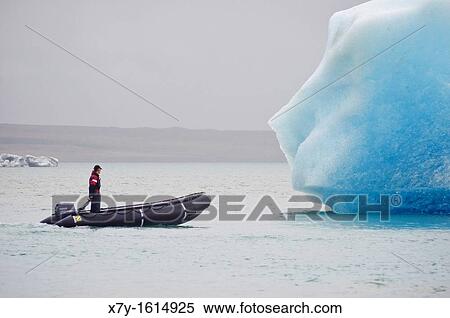 A man in a raft approaches an iceberg in Glacier Lagoon, Iceland View Large Photo Image Stock Photography - A man in a raft approaches an iceberg in Glacier Lagoon, Iceland. Fotosearch